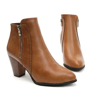 Detailed side view of brown faux leather ankle boots with block heel and zipper