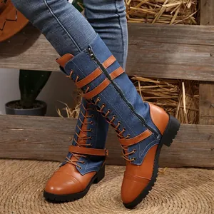 Detailed macro view of denim and leather spliced tall knight boots with buckles and laces