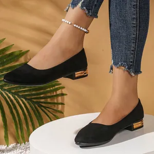 Detail of black suede pointed toe flats featuring elegant gold metallic heel trim.