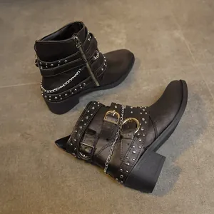 Botines negros de estilo punk con tachuelas, hebillas y cadenas metálicas