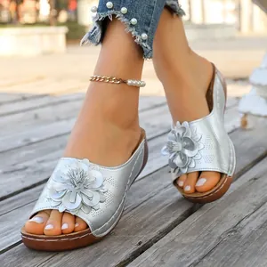 Stylish silver wedge sandals for women featuring elegant flower decoration and wood-textured sole