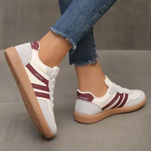 Close-up of retro GAT sneakers with burgundy stripes and grey suede details