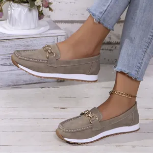 Detailansicht stilvoller khakifarbener Slipper aus Wildlederimitat mit goldener Kette.