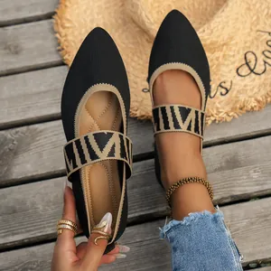 Close-up of breathable black flyknit pointed-toe flats with patterned strap details.