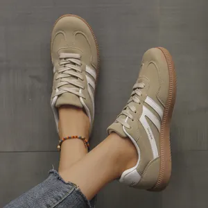 Detailed view of women's vintage beige GAT sneakers with white stripe accents on floor