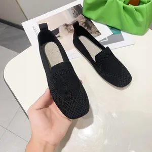 Detailed close-up of black breathable fly-knit flat shoes with stylish square toe