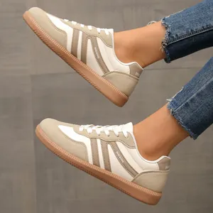 Detailed side view of beige retro color-block sneakers on model with denim jeans