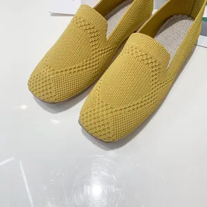 Close-up view showing the breathable yellow fly-knit texture and square-toe design of these flats