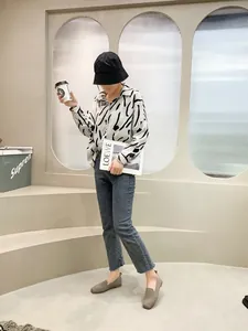 Full-body view of a model wearing breathable beige knit flat shoes in a minimalist setting.