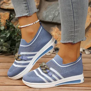 Detail shot of women's blue knitted slip-on sneakers with gold chain detail and white sole