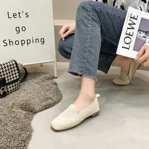Detailed view of beige knit square-toe flats worn by a model in a trendy shopping scene