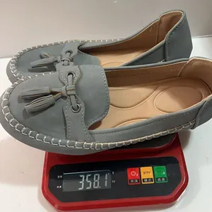 Lightweight grey women's soft loafers with tassels on a weighing scale for 358.1g