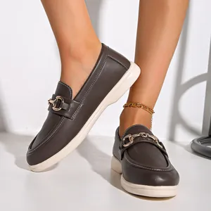 Detailansicht brauner Damen-Loafer mit goldener Schnalle und weißer Sohle.