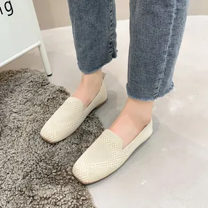 Close-up view of beige knit flat loafers with a stylish square toe and breathable fabric texture