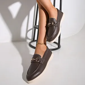 Detailansicht von braunen Vintage-Damen-Loafern mit einer eleganten goldenen Schnalle