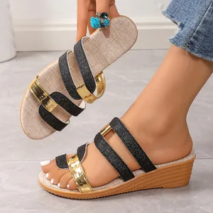 Detail of black and gold glitter wedge sandals with a comfortable cork-style heel