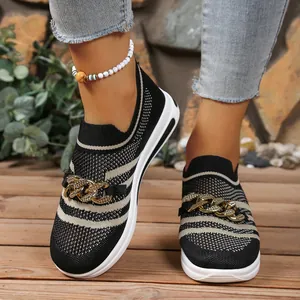 Close-up detail of women's striped knit slip-on sneakers with gold chain accent