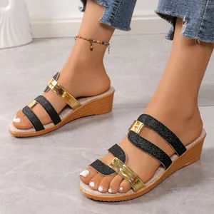 Detail view of black glitter and gold metallic straps on women's summer wedge sandals.
