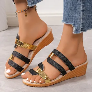 Detailed view of comfortable wedge sandals featuring gold and black glitter straps on feet