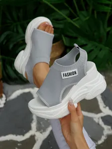 Gedetailleerd overzicht van grijze fly-knit platformsandalen met dikke witte zolen
