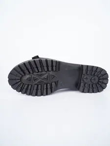 Detailed view of the durable chunky lug sole pattern on black patent leather loafers