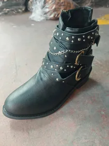 Vista detallada de botín punk negro con tachuelas, cadenas y hebillas doradas