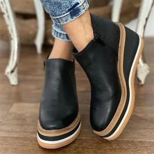Side view of women's black leather wedge ankle boots with thick striped sole
