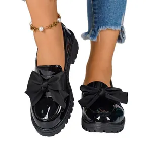 Women's black patent leather platform loafers featuring stylish oversized decorative bows