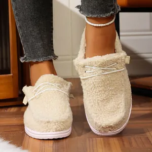 Detail view of cozy cream fuzzy winter slippers with stylish white decorative laces