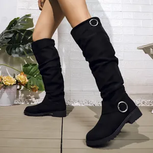 Detailed view of black suede slouchy mid-calf boots with decorative metal ring buckles