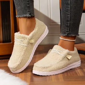 Close-up of women's cozy fleece loafers with thick soles worn on wooden floor.