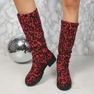 Close-up detail of red leopard print slouchy boots with chunky heels and soft suede texture.