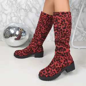 Close-up view of red leopard print suede slouchy boots with chunky black soles