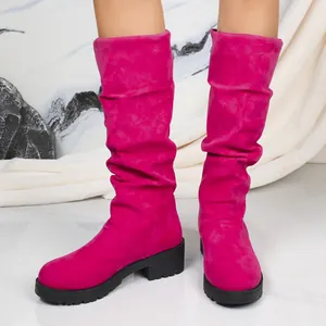 Detailed view of women's vibrant magenta suede slouch boots with chunky black block heels