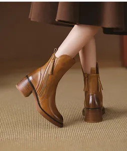 Detail view of vintage tan leather mid-calf boots with side zipper and chunky heel.