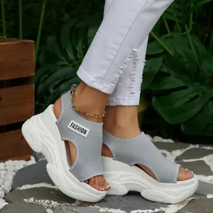 Stijlvolle grijze fly-knit sandalen met sleehak en een dikke witte plateauzool voor