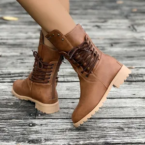 Close-up detailed view of brown mid-calf lace-up boots with studs and side zipper