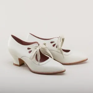 Elegant white vintage-style pumps with teardrop hollow details and lace-up ribbon front.