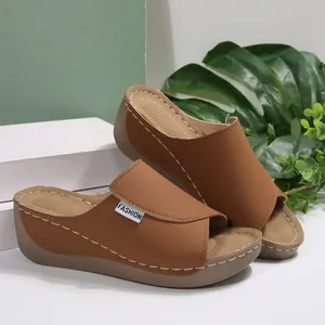 Close-up of stylish brown wedge peep toe sandals with elegant white stitching details