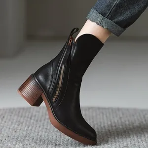 Elegant black leather mid-calf boots featuring a chunky brown heel and side zipper detail