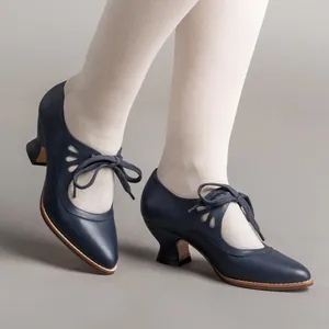 Detail view of navy blue vintage lace-up high heels with teardrop cutouts