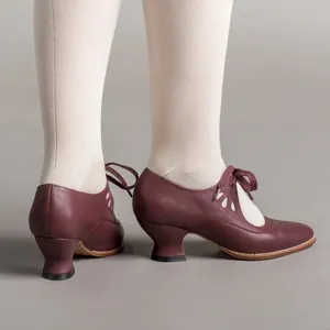 Detailed side view of burgundy vintage-style lace-up pumps featuring hollow patterns