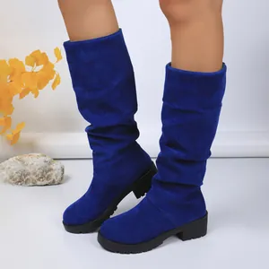 Fashionable blue suede slouchy mid-calf boots featuring a chunky black lug sole design