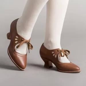 Close-up of vintage brown leather lace-up high heels with cutout details on white socks