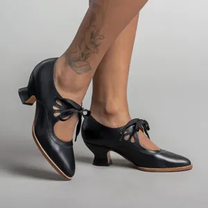 Elegant vintage black leather high heel shoes with lace-up ribbon and cutout detailing.