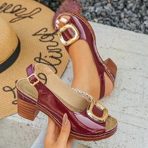 Close-up of wine red patent leather peep-toe sandals with chunky heels and gold buckle
