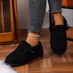 Detailed macro view of comfortable black fuzzy plush slip-on loafers with elastic cross laces