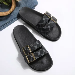 Detailopname van zwarte platform slippers met verstelbare dubbele gespen en bloemenpatroon