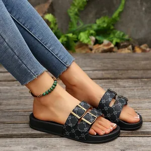 Detail van comfortabele zwarte slippers met dikke zool en verstelbare dubbele gespen.