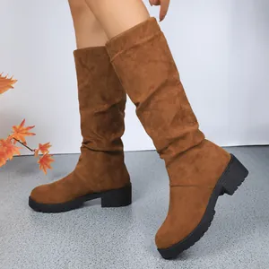 Detailed view of women's brown suede slouchy mid-calf boots with a chunky black sole